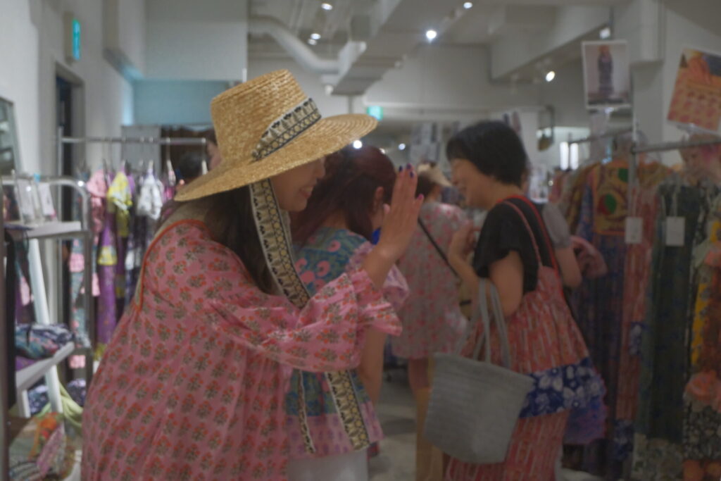 大阪のポップアップで、お客様と笑顔で話すnioki店主。手仕事の服を実際に手に取って体験できる場所。