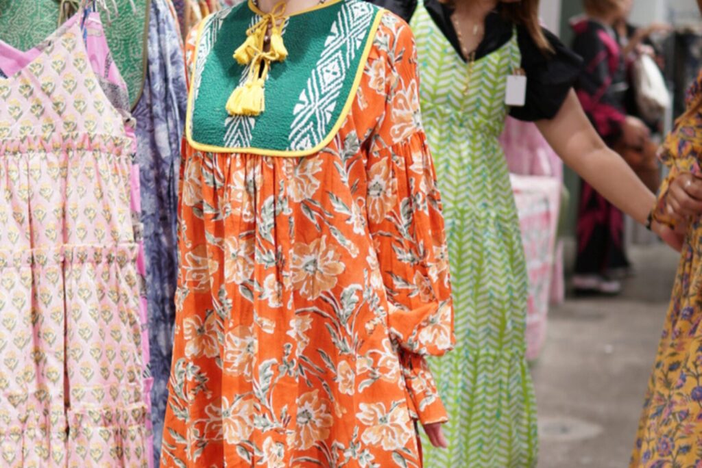 夏の暑さを吹き飛ばすような、鮮やかなオレンジのブロックプリントワンピース。大人の洗練された色合わせ。